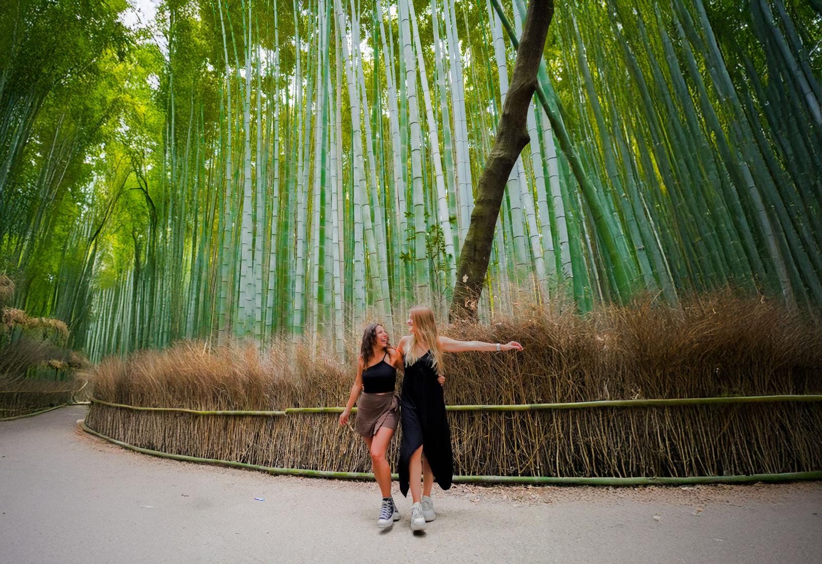 Zwei Menschen laufen im üppigen, grünen Bambuswald von Arashiyama, Kyoto, Japan.