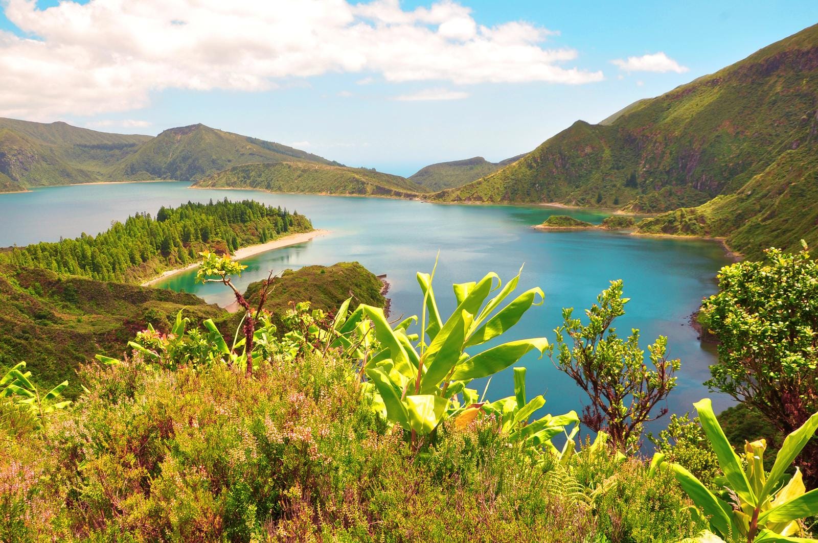 Blaue Lagune in grüner Hügellandschaft, Azoren, Portugal, sonnig und idyllisch.