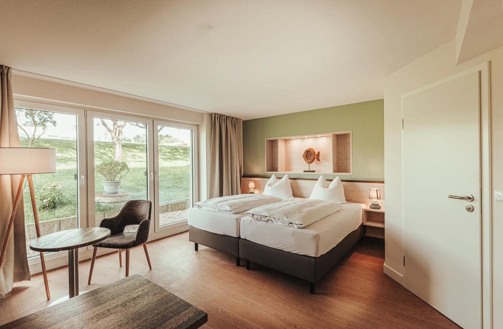 Gemütliches Hotelzimmer im BE BIO Hotel mit Blick auf grünen Garten.