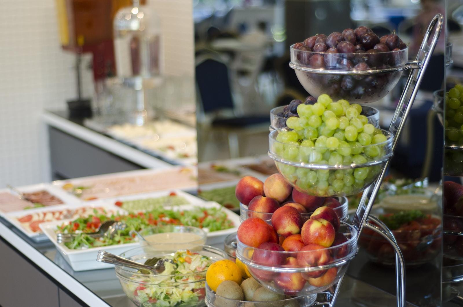 Ein reichhaltiges Frühstücksbuffet mit Obst und Salat, typischerweise in einem Hotel in Italien.