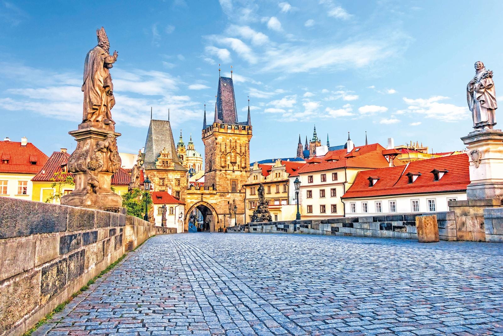 Die Karlsbrücke in Prag, Tschechien, bei sonnigem Wetter, umgeben von historischer Architektur.