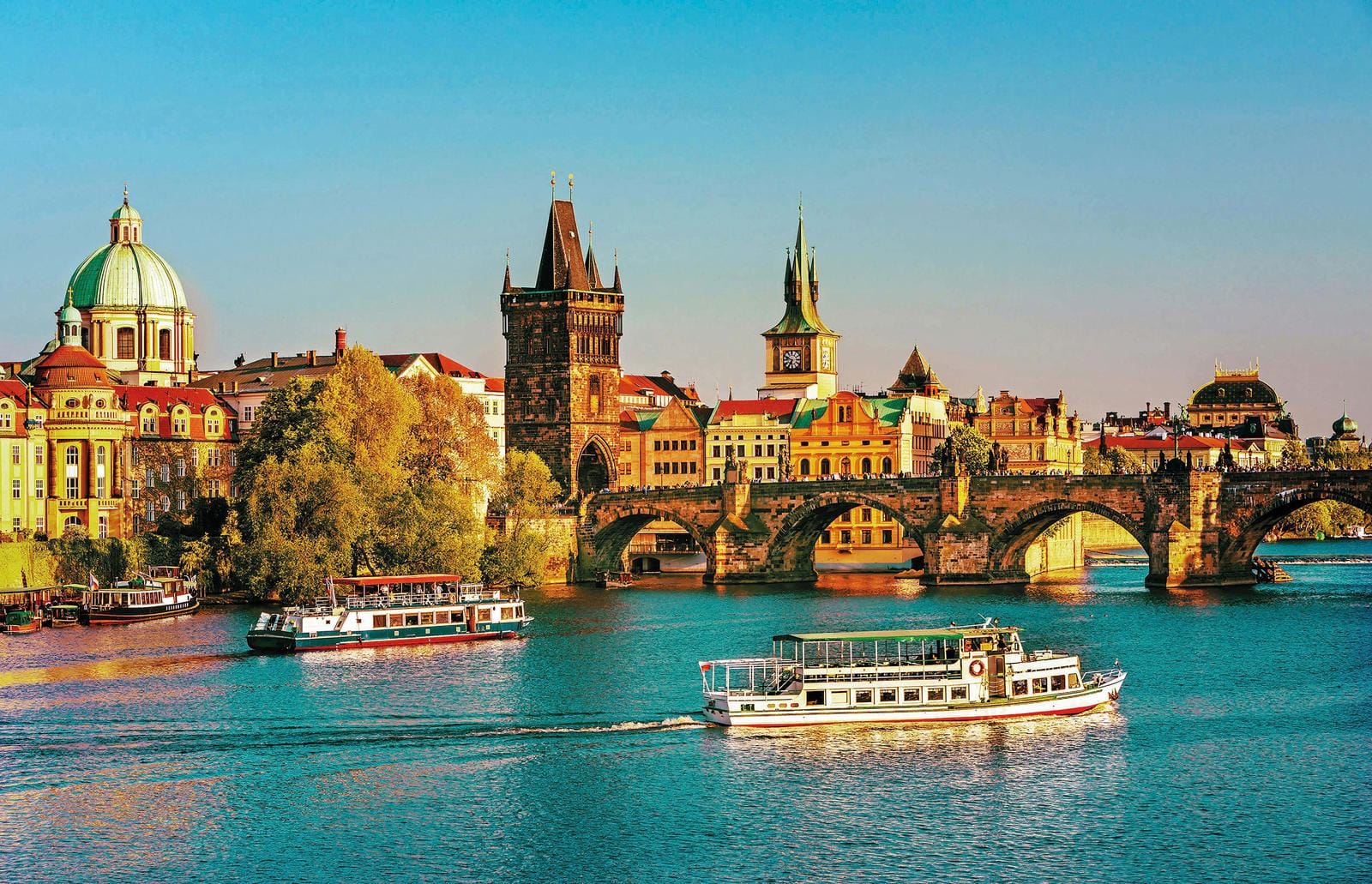 Bootsfahrt bei sonnigem Wetter in Prag, Tschechien, mit historischem Brückenblick.