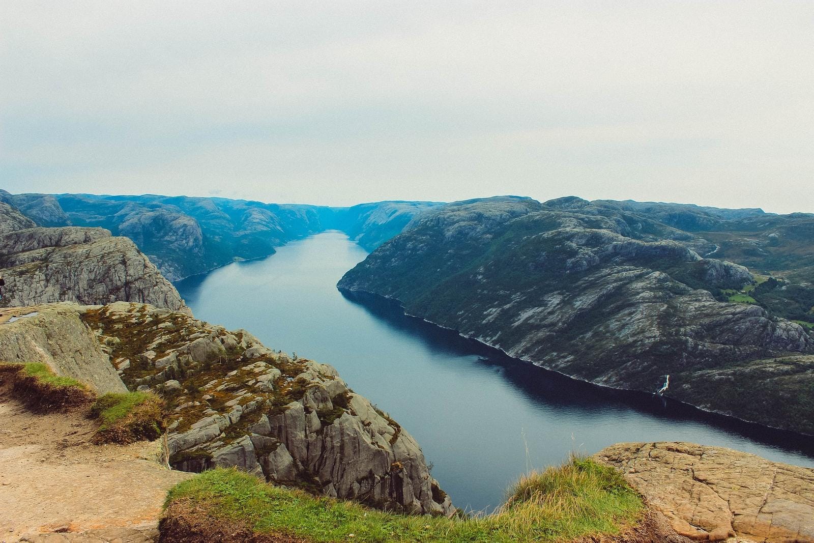 Majestätischer Fjord in Norwegen, umgeben von beeindruckenden Felsen und tiefblauem Wasser.