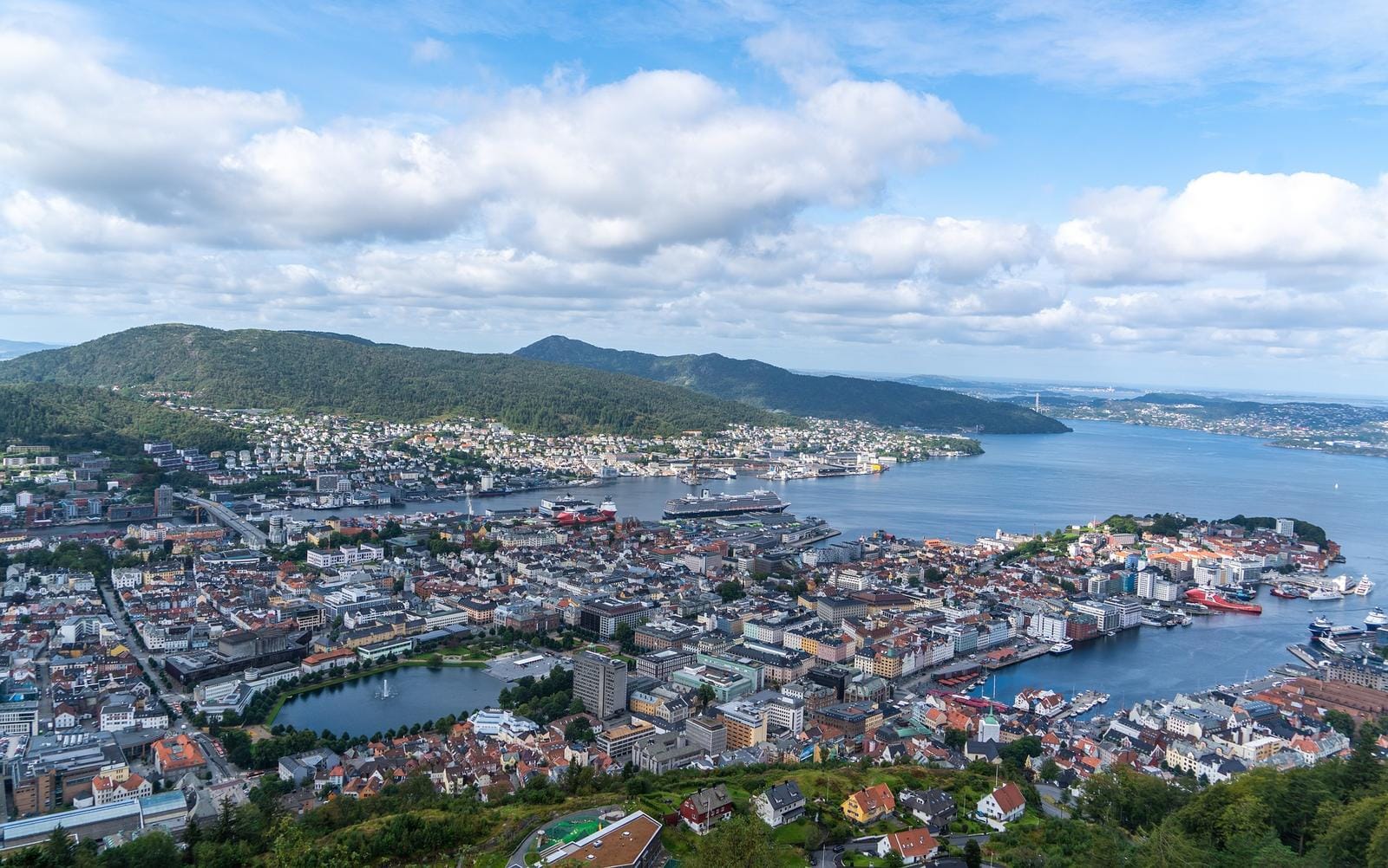 Panoramablick auf Bergen in Norwegen: Hafenstadt umgeben von grĂĽnen HĂĽgeln und Wasser.