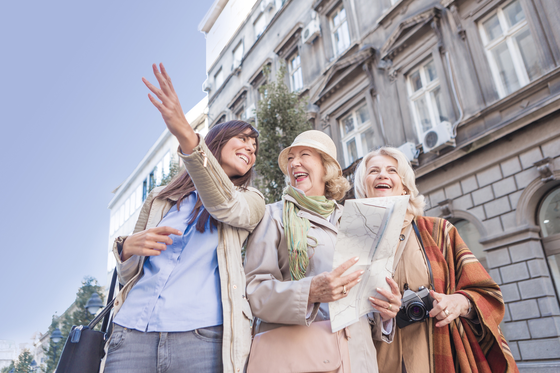 Two senior ladies, tourist traveling, exploring the city, asking young woman, passenger for directions, browsing city map, discovering landmarks.